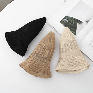 Flat lay of breathable knitted sun hats in black, khaki, and cream for summer