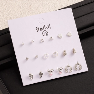 Detailed close-up of 9-pair silver earring set with pearls and diverse geometric shapes