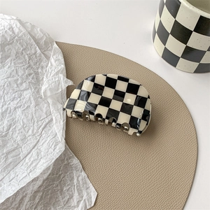 Detail of checkered black and white hair claw clip with smooth acetic texture
