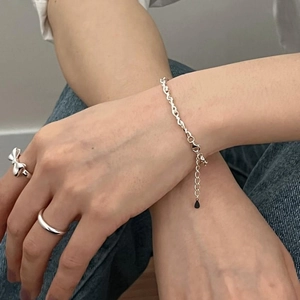 Detailed view of S925 sterling silver beaded bracelet and bow ring worn on person