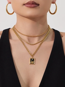 Detail of 18k gold plated layered necklace with square pendant and matte hoop earrings
