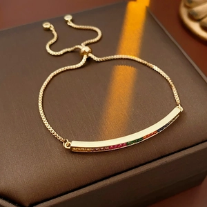 Detail of adjustable gold bracelet with colorful cubic zirconia on leather box