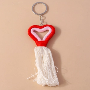Handmade woven heart keychain with red and pink patterns and long white tassel fringe