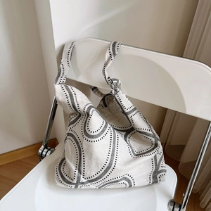 Minimalist cotton linen tote bag with black geometric print on a white folding chair