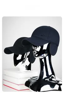Close-up of winter baseball caps with ear flaps and metal logo on silver models