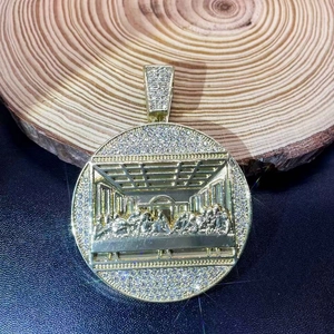 Macro view of gold round Last Supper pendant with shimmering pavé diamond accents