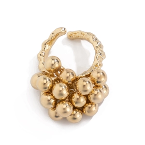 Macro shot of gold metallic ring with cluster pearls and irregular textured band