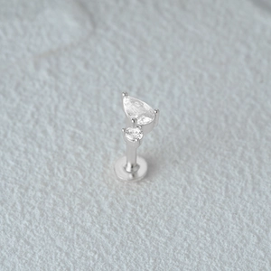 Macro shot of silver cartilage earring with teardrop and round zircon stone details