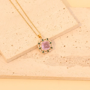 Vintage gold necklace with pink square gemstone and green teardrop crystals on stone