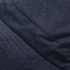 Detailed macro view of water droplets on waterproof dark blue outdoor sun hat fabric