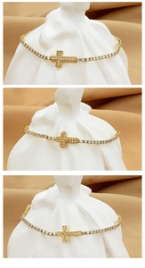 Detailed view of three gold tennis bracelets featuring zircon-encrusted cross pendants
