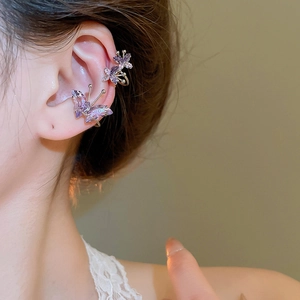 Detailed view of elegant purple zircon butterfly ear cuffs worn on woman's ear cartilage