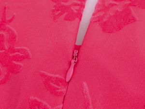 Vue détaillée du tissu jacquard floral rose avec une fermeture éclair invisible