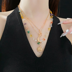 Detail of layered bohemian necklace with colorful stones, moon and star pendants