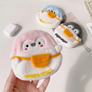 Detailed close-up of cute plush penguin coin purses in pink, blue, and grey soft fabric