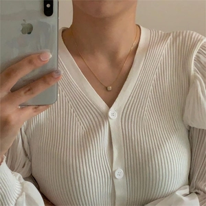 Detailed mirror selfie showing a delicate gold cubic zirconia square pendant necklace