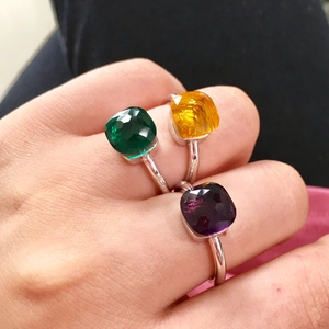 Three faceted crystal rings in green, orange, and purple on silver-plated bands