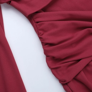 Gros plan sur les détails de fronces latérales d'une robe moulante rouge à épaules nues