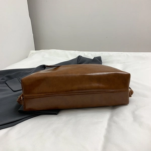 Brown leather tote bag featuring durable bottom stitching and gold metal hardware