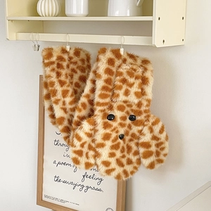 Detail of plush scarf with giraffe pattern and cartoon dog design for winter warmth