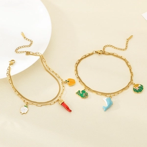 Détail de bracelets de cheville dorés à double couche avec pendentifs fruits et mer
