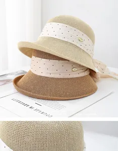 Détail du tissage en paille et ruban à pois avec une boucle dorée logotée