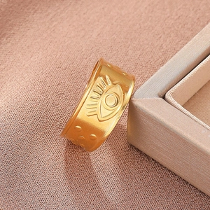 Detailed close-up of wide gold-plated ring with Evil Eye and dot relief engraving