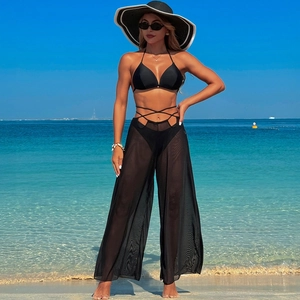 Detail view of black 3-piece swimwear with bikini and sheer mesh wide-leg cover-up pants