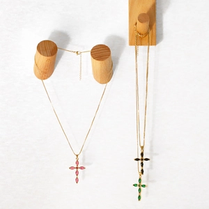 Detailed view of colorful marquise zircon cross necklaces in gold-tone metal chains