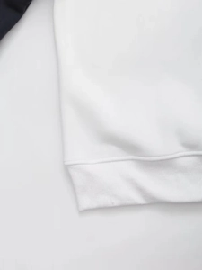 Detail of white ribbed knit cuffs and hem on a relaxed fit casual sweatshirt
