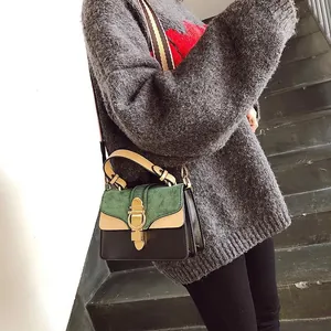 Close-up of tricolor crossbody bag featuring metal buckle and woven strap on model