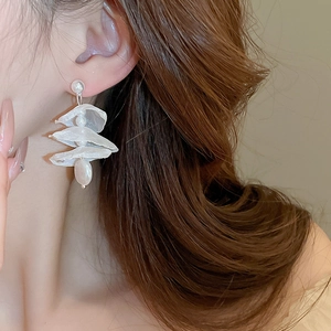 Detailed close-up of white organza lace petal earrings with elegant faux pearl accents