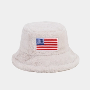 Vue détaillée du chapeau bob en peluche beige avec un écusson brodé drapeau américain