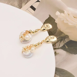 Baroque pearl drop earrings with 18k gold plating on a white decorative tray