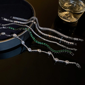 Détail de bracelets tennis argentés avec zircons verts sur plateau velours
