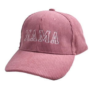 Close-up of pink corduroy baseball cap featuring white embroidered MAMA lettering texture