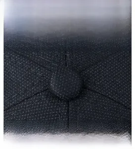 Vue macro de la casquette en maille foncée montrant le bouton supérieur recouvert de tissu