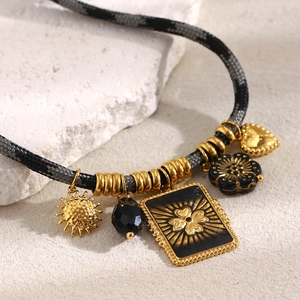Close-up of woven rope necklace with 18K gold flower, sun, and clover square pendants