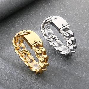 Makro-Detail von gold- und silbernen Panzerarmbändern mit Kastenverschluss auf Stein-Hintergrund