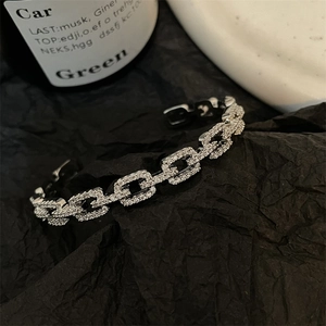 Macro detail of silver-colored pavé chain bracelet with white cubic zirconia inlay