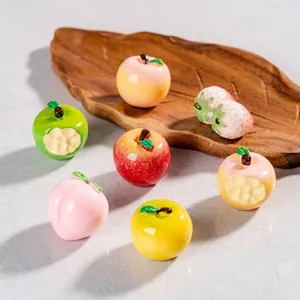 Detailed view of mini resin fruit charms including apples, peaches and strawberries