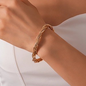 Detailed close-up of a layered gold wrap bracelet with shimmering rhinestones on a wrist
