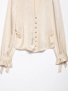 Détail d'une chemise en soie champagne avec texture jacquard et boutons métalliques