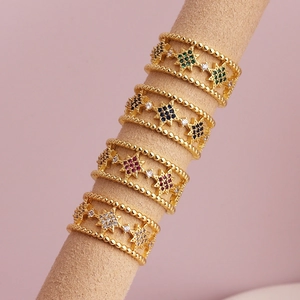 Gold starburst ring with multicolor micro-pave zircons on a beige velvet ring stand