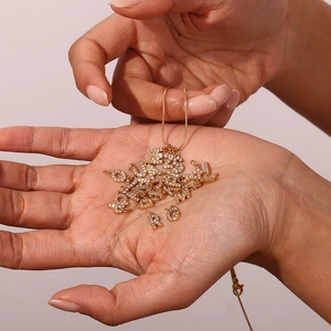 Detalle de mini colgantes de letras bañados en oro 18K con pedrería en cadena de serpiente