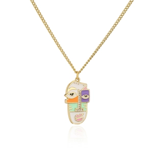 Macro detail of abstract face pendant with colorful enamel and zircon inlay on gold chain