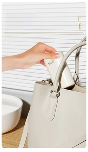 Étui de brosse à dents de voyage blanc avec logo doré rangé dans un sac à main élégant