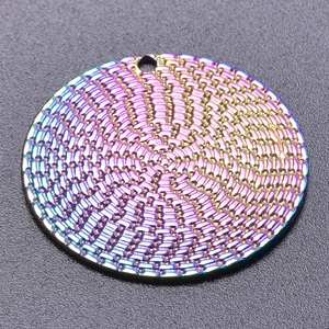 Close-up of a round rainbow electroplated pendant with spiral 3D embossed textures