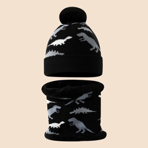 Close-up of boys dinosaur knit hat and scarf set with fleece lining and faux fur pom