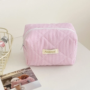 Detail of pink candy striped quilted makeup bag with Purdored label and zip closure